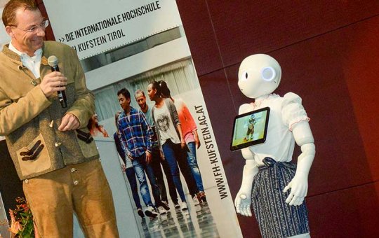 FH-Geschäftsführer Prof. (FH) Dr. Thomas Madritsch im Gespräch mit Roboter Pepper