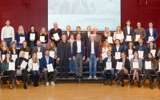 Die ausgezeichneten Studierenden (nicht alle anwesend) mit den Urkunden des Ministeriums und VertreterInnen der Studiengänge. (FH-Rektor Prof. (FH) Mario Döller, erste Treppenreihe Mitte)