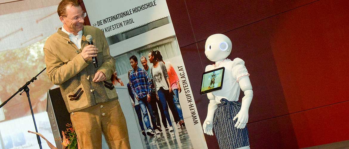 FH-Geschäftsführer Prof. (FH) Dr. Thomas Madritsch im Gespräch mit Roboter Pepper